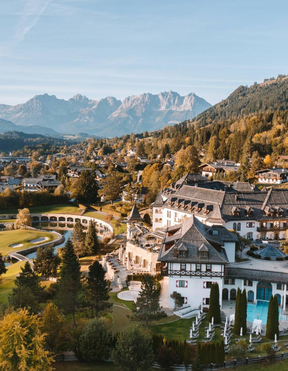Schlosshotel Kitzbühel am See vor herbstlich gefärbten Bergen