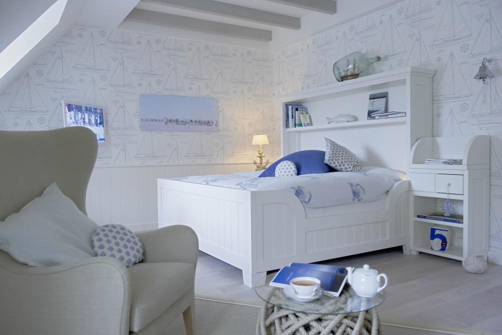 Lösch ruhiges helles Schlafzimmer mit weißem Bett, Stuhl und nautischem Dekor