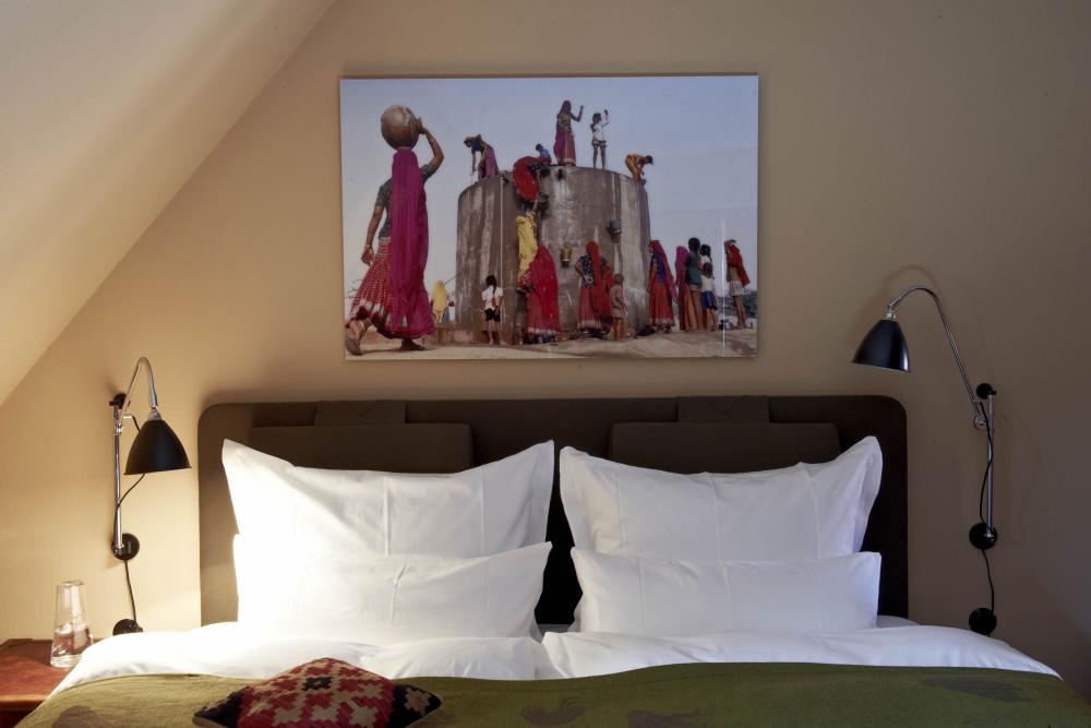 Lösch-Bild über einem Bett zeigt Frauen beim Wasserholen an einem Brunnen