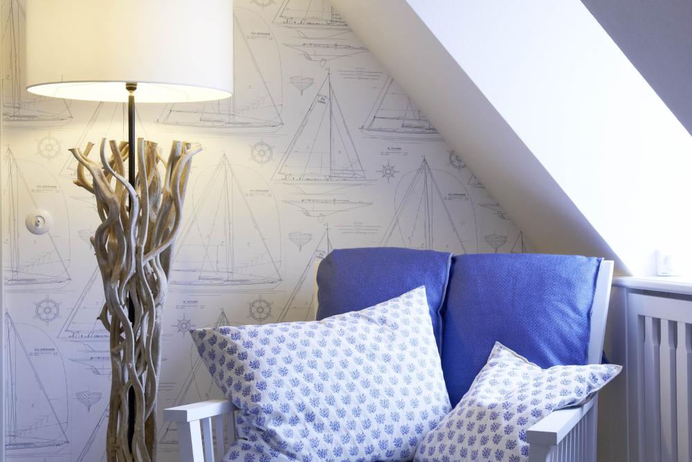 Gemütliche Sitzecke mit Lösch-Lampe und maritimen Kissen unter Dachschräge