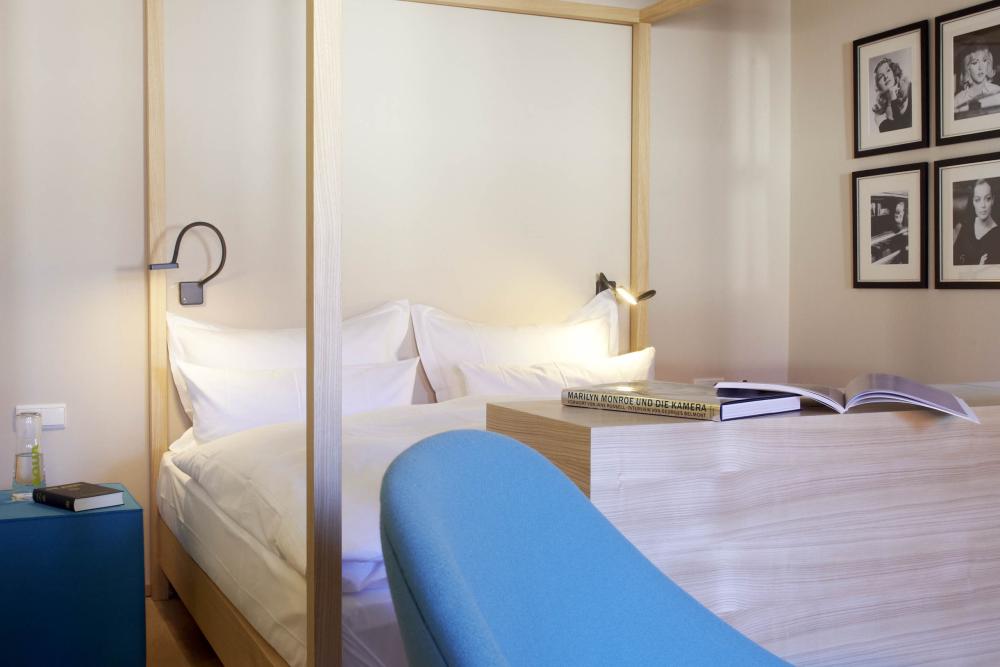 Modernes Schlafzimmer mit Lösch Bett und blauem Sessel