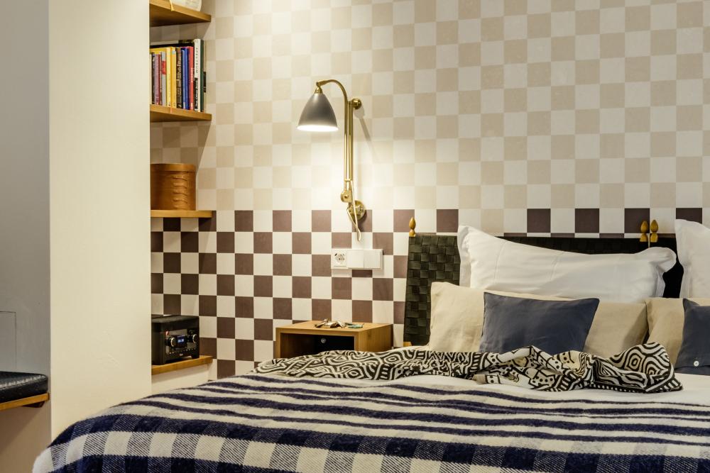 Gemütliches Schlafzimmer mit Karomuster an Wand und Bett im Kloster Hornbach