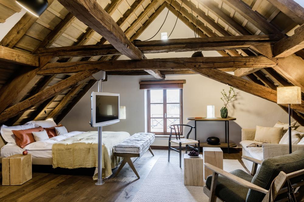 Modernes Gästezimmer mit Holzbalken im Dachstuhl im Kloster Hornbach