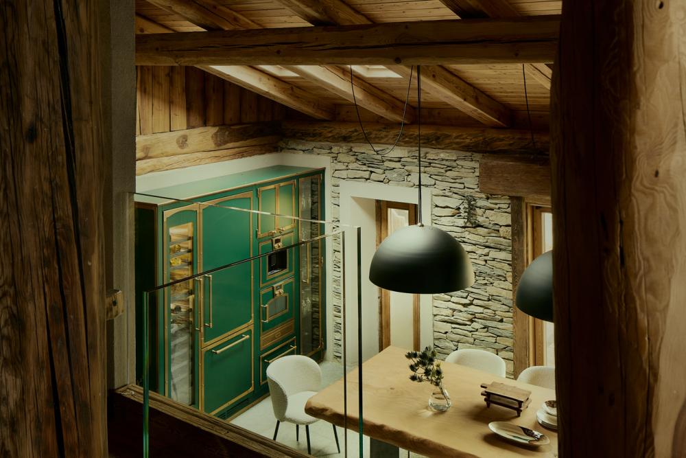 Baita Horres con sala da pranzo rustica, travi in legno e parete in pietra