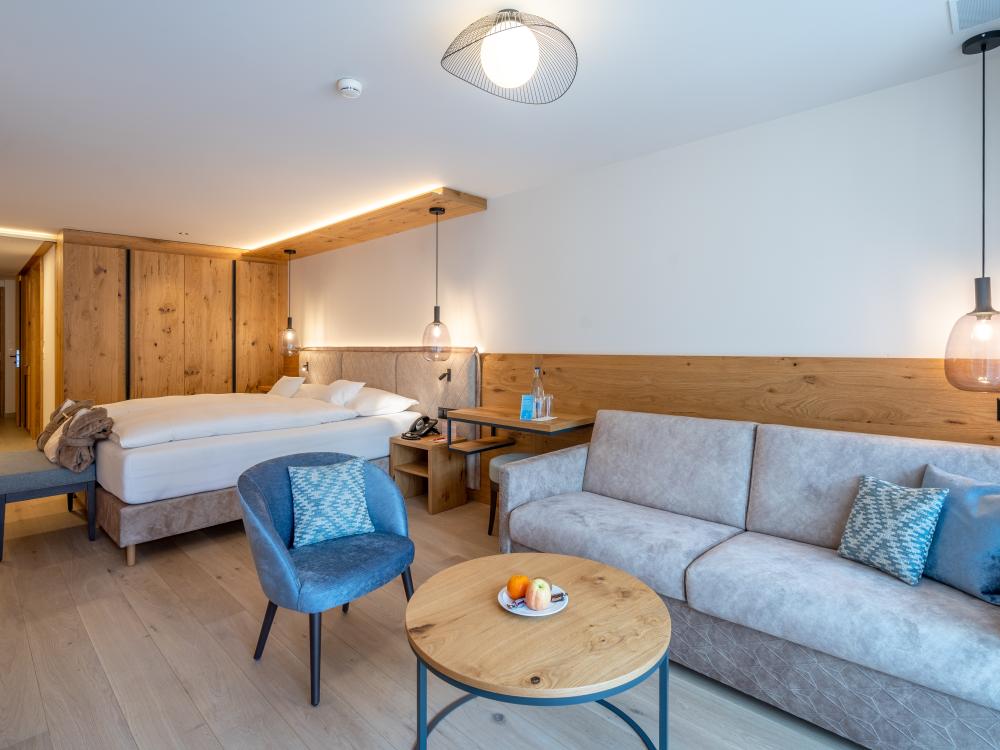 Chambre moderne au Resort La Ginabelle Zermatt avec accents en bois et coin salon