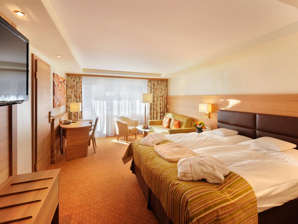 Cozy room at Resort La Ginabelle Zermatt with double bed and seating area