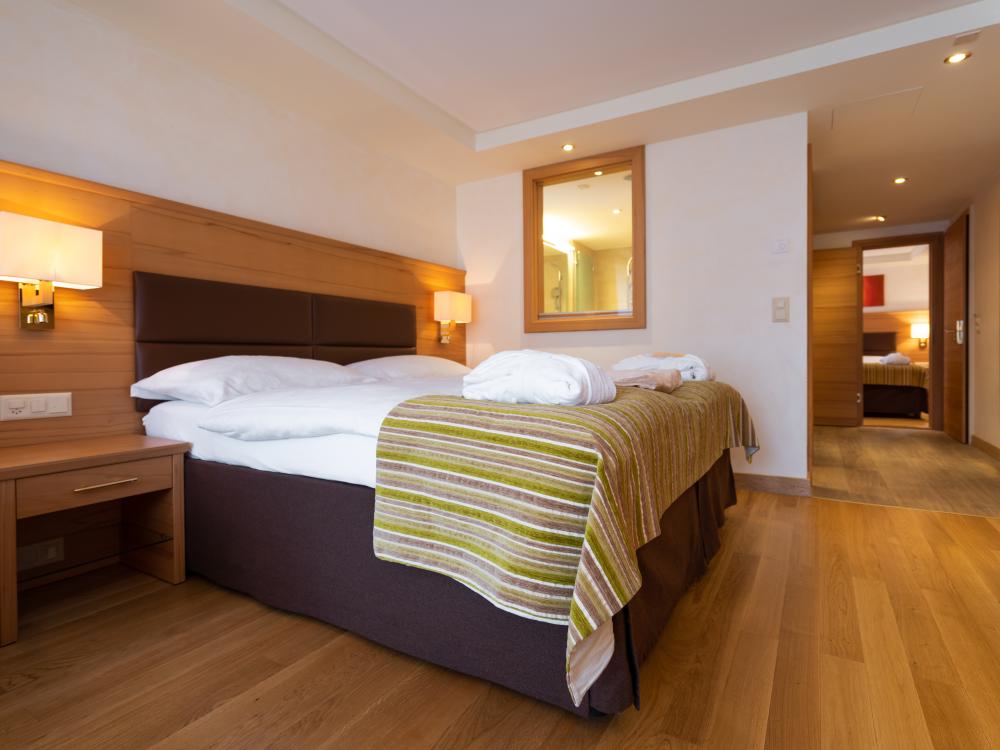 Cozy bedroom at Resort La Ginabelle Zermatt with double bed and wooden decor