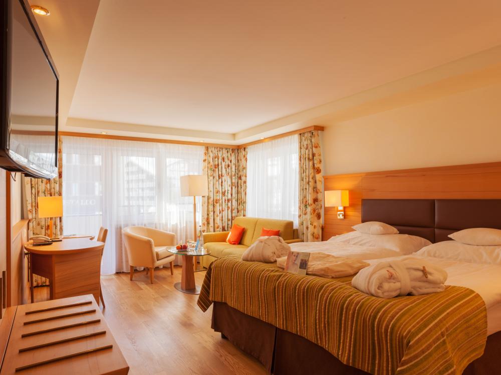 Cozy double room at Resort La Ginabelle Zermatt with seating area and TV
