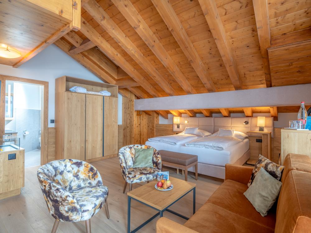 Cozy room at Resort La Ginabelle Zermatt with wooden ceiling and seating area