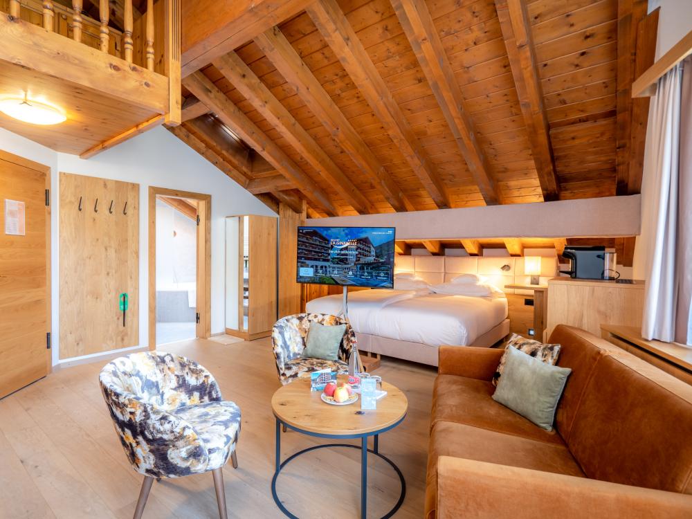 Cozy room at Resort La Ginabelle Zermatt with wooden ceiling and seating area