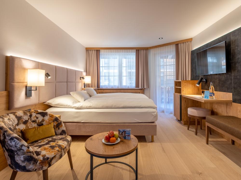 Cozy room at Resort La Ginabelle Zermatt with two beds and seating area