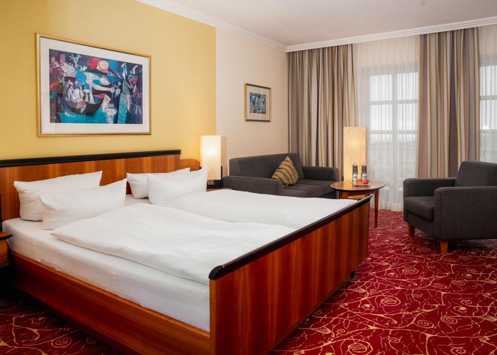 Gemütliches Zimmer im Sport- und Wellnesshotel Angerhof ****S mit Doppelbett und Sitzbereich