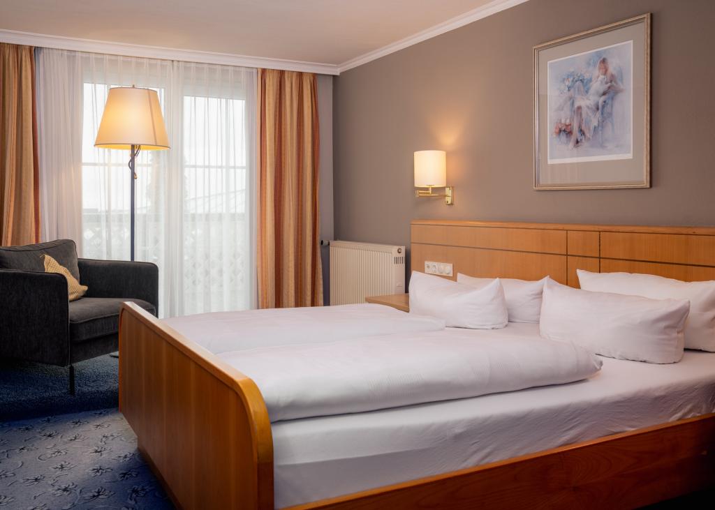 Gemütliches Zimmer im Sport- und Wellnesshotel Angerhof ****S mit Bett und Sitzbereich