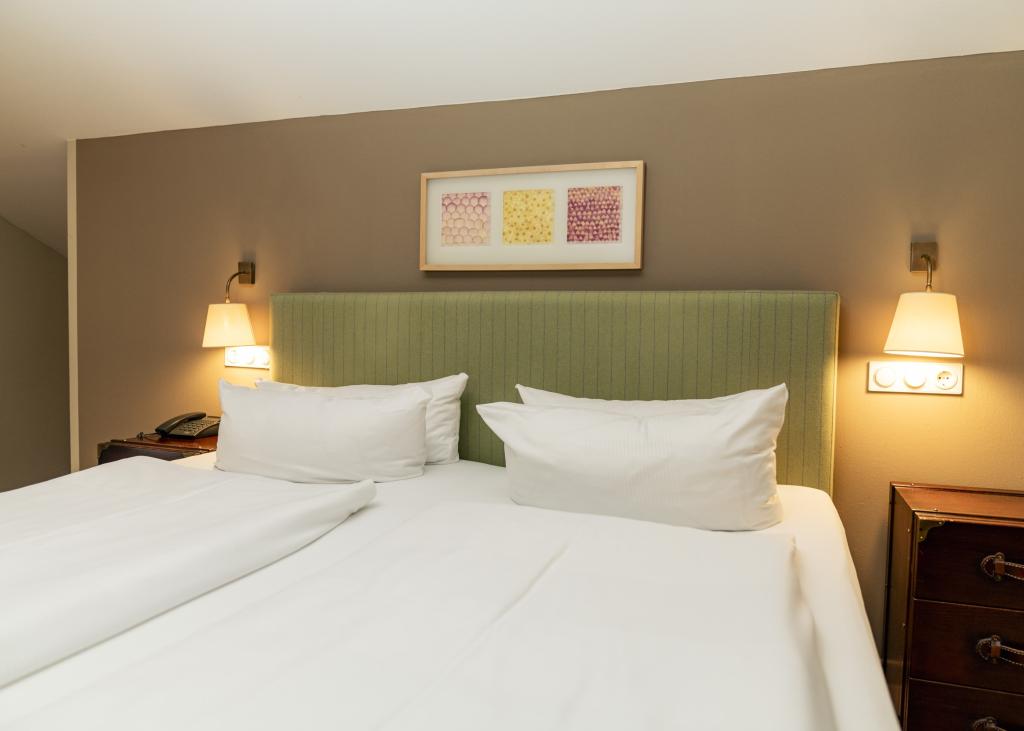Modernes Hotelzimmer im Sport- und Wellnesshotel Angerhof ****S mit grünem Kopfteil
