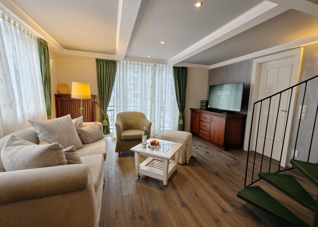 Gemütlicher Wohnbereich im Sport- und Wellnesshotel Angerhof ****S mit Sofa und TV