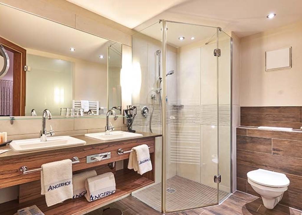 Modernes Badezimmer im Sport- und Wellnesshotel Angerhof ****S mit Dusche und Waschbecken