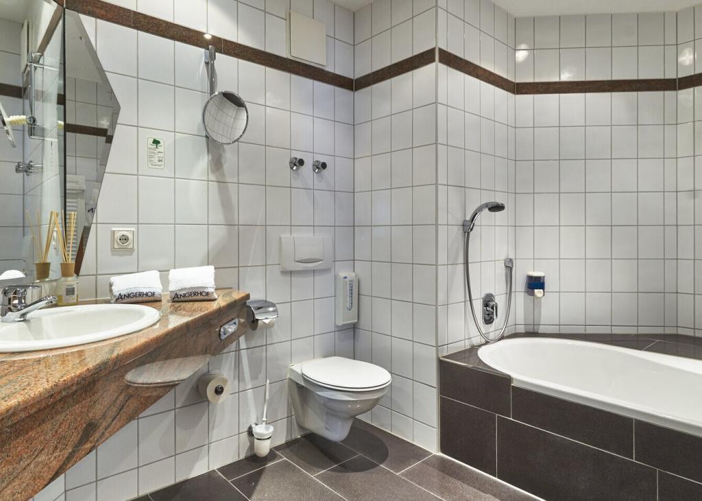 Modernes Badezimmer im Sport- und Wellnesshotel Angerhof ****S mit Wanne und Waschbecken
