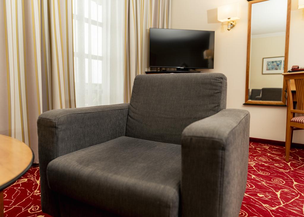 Gemütlicher Sessel und TV im Zimmer des Sport- und Wellnesshotel Angerhof ****S