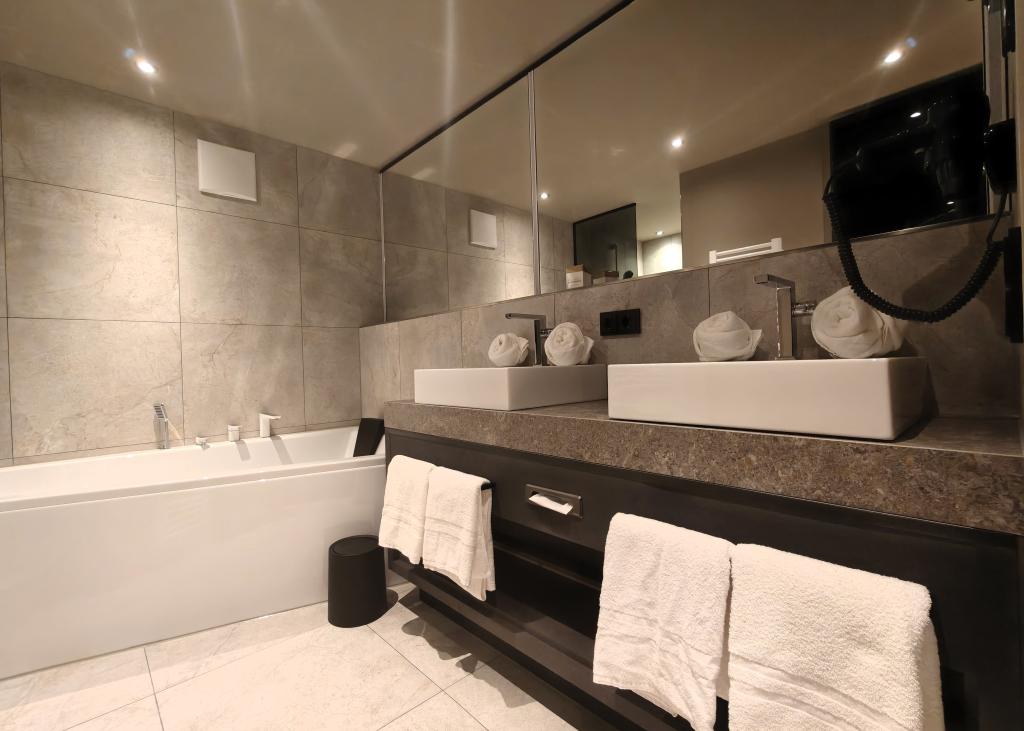 Modernes Badezimmer im Sport- und Wellnesshotel Angerhof ****S mit Badewanne und Waschbecken