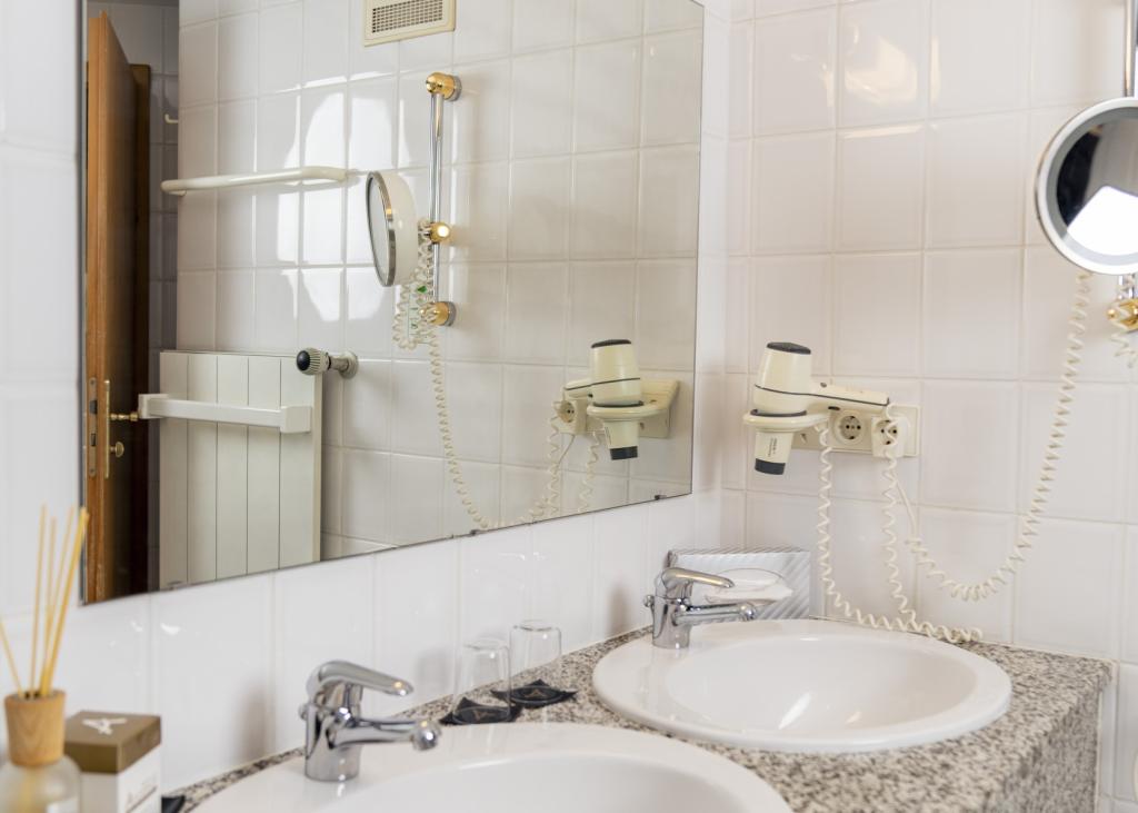 Badezimmer mit zwei Waschbecken im Sport- und Wellnesshotel Angerhof ****S.