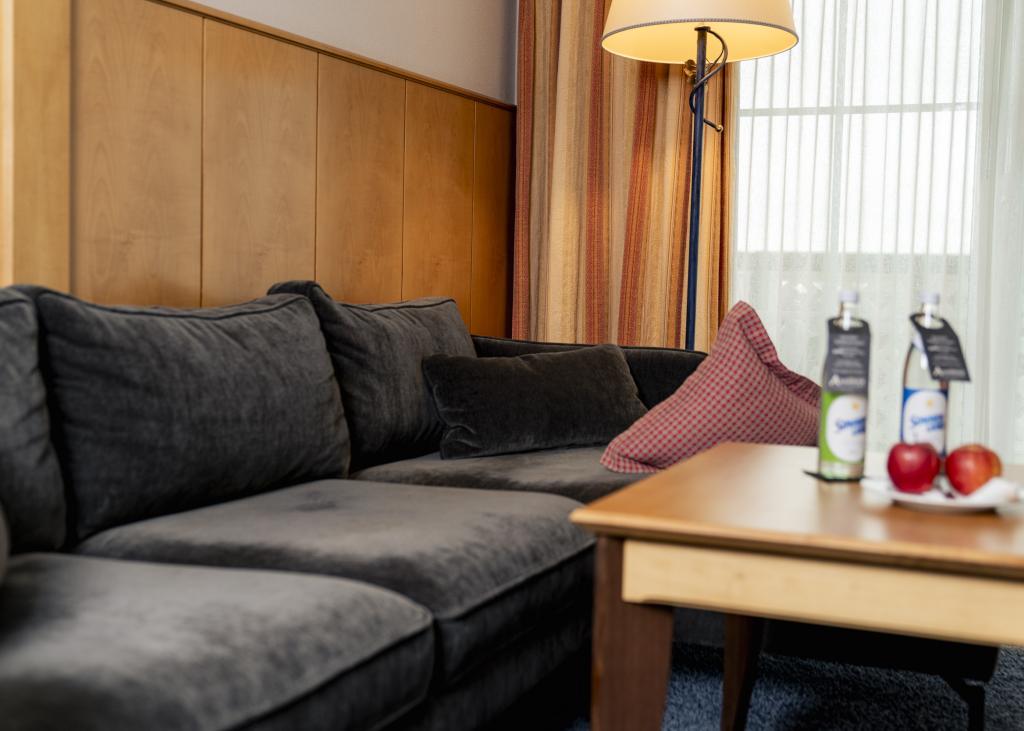Gemütliche Sitzecke im Sport- und Wellnesshotel Angerhof ****S mit Sofa und Lampenlicht