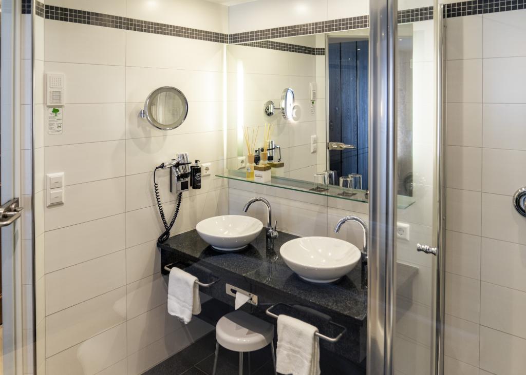 Modernes Badezimmer mit Doppelwaschbecken im Sport- und Wellnesshotel Angerhof ****S