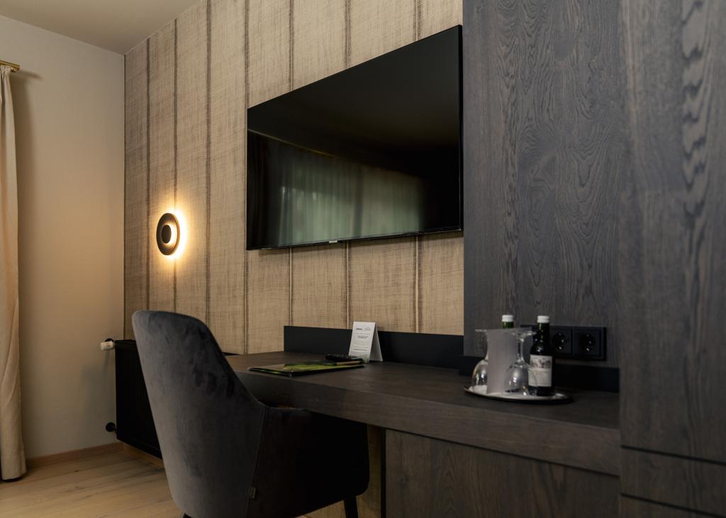 Moderner Arbeitsbereich im Sport- und Wellnesshotel Angerhof ****S mit Fernseher und Sitzgelegenheit
