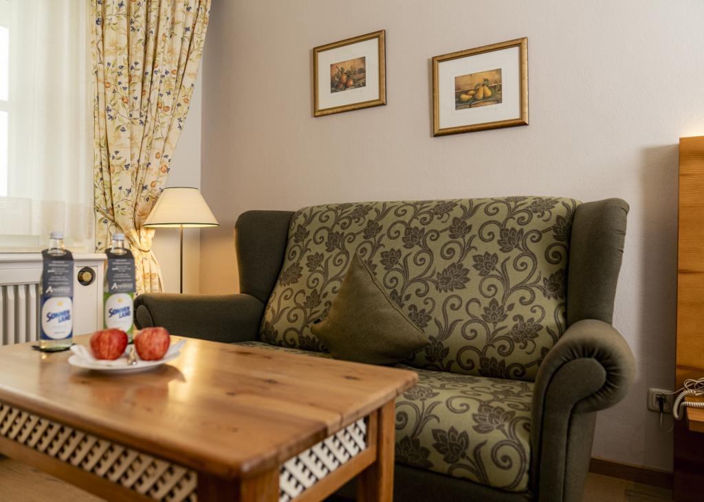 Gemütliche Sitzecke im Sport- und Wellnesshotel Angerhof ****S mit Sofa und Holztisch.