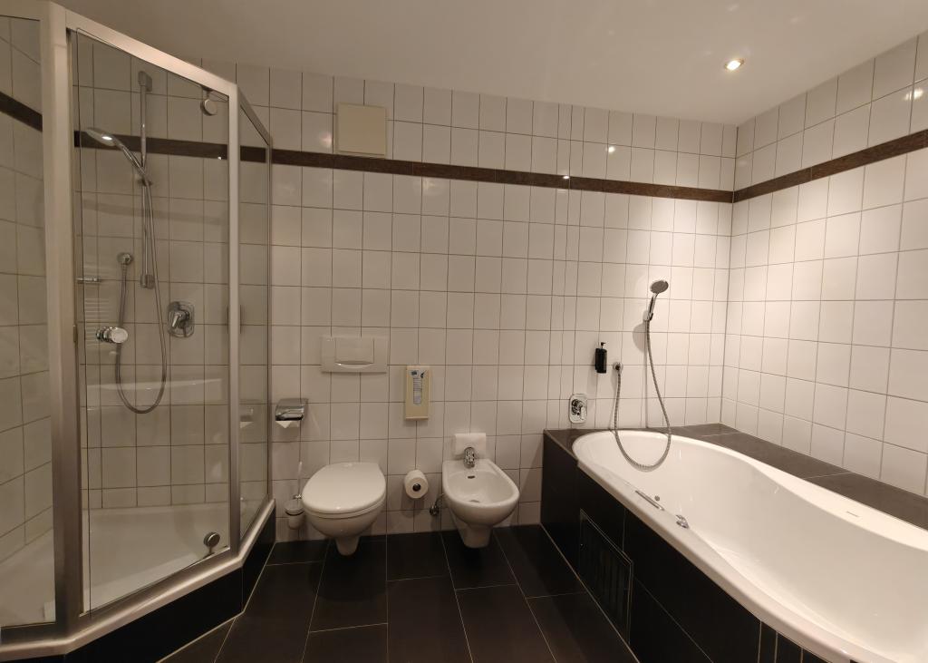 Modernes Badezimmer im Sport- und Wellnesshotel Angerhof ****S mit Dusche, Badewanne und WC.