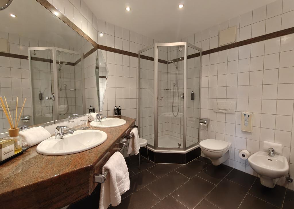 Modernes Badezimmer im Sport- und Wellnesshotel Angerhof ****S mit Doppelwaschbecken und Dusche