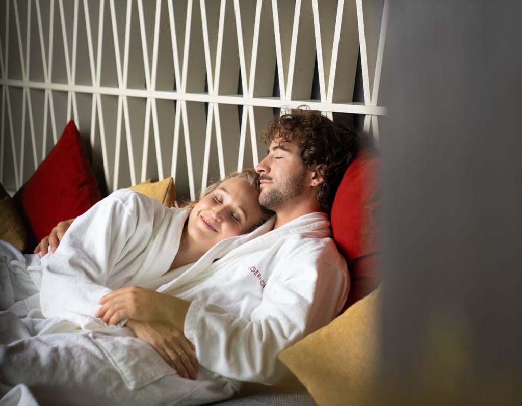 Paar entspannt im Sport- und Wellnesshotel Angerhof ****S in weißen Bademänteln