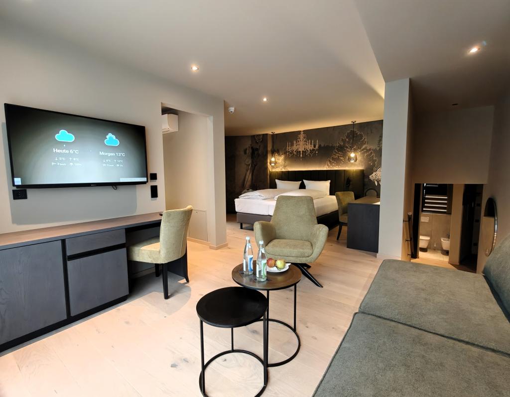 Modernes Hotelzimmer im Sport- und Wellnesshotel Angerhof ****S mit Sitzbereich und TV