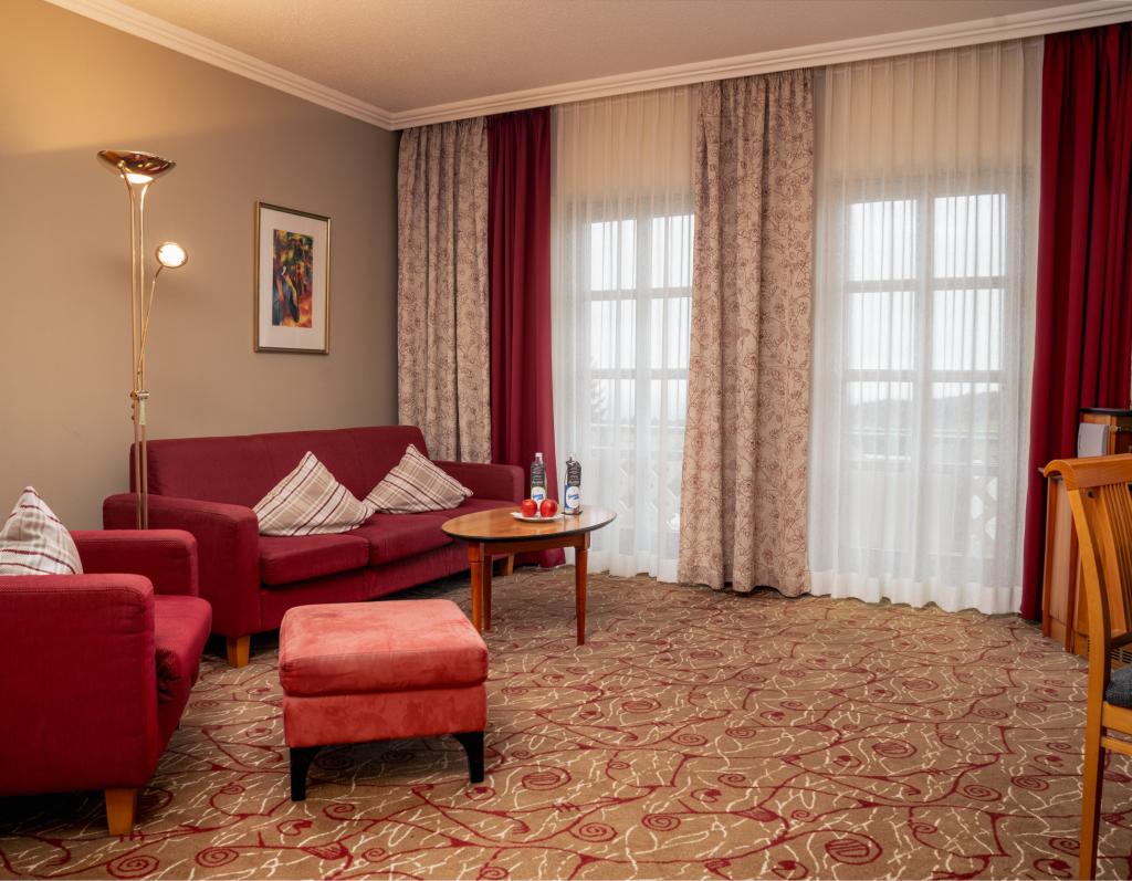 Gemütlicher Wohnbereich im Sport- und Wellnesshotel Angerhof ****S mit roten Möbeln