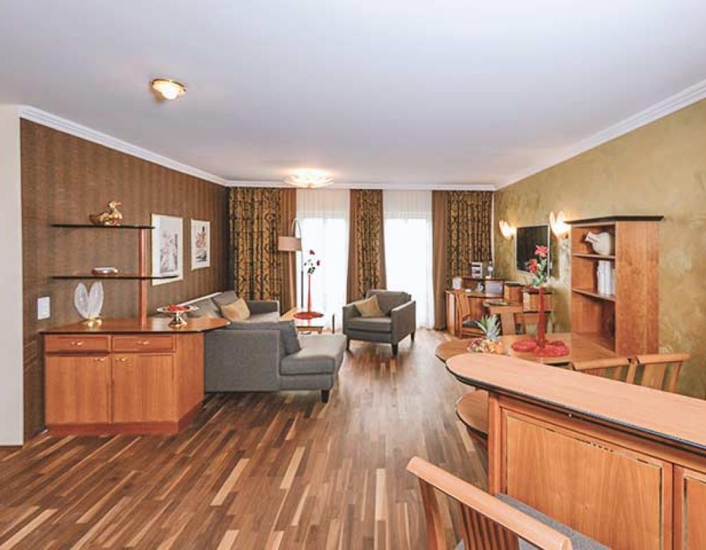 Gemütlicher Wohnbereich im Sport- und Wellnesshotel Angerhof ****S mit Holzmöbeln und Sofas
