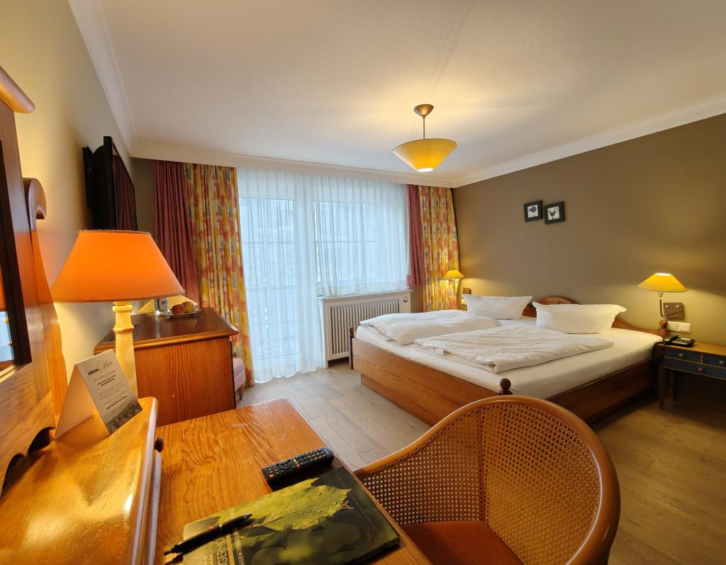 Gemütliches Zimmer im Sport- und Wellnesshotel Angerhof ****S mit Doppelbett und Holzmöbeln