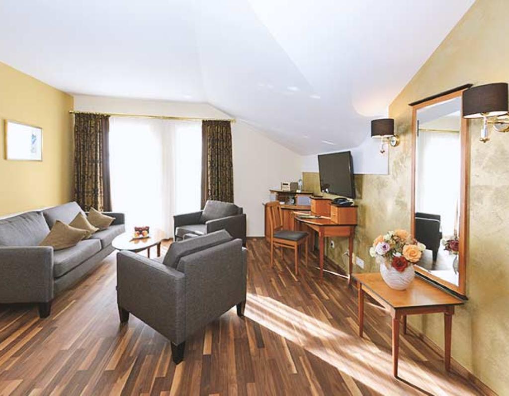 Gemütlicher Wohnbereich im Sport- und Wellnesshotel Angerhof ****S mit Sofas und TV