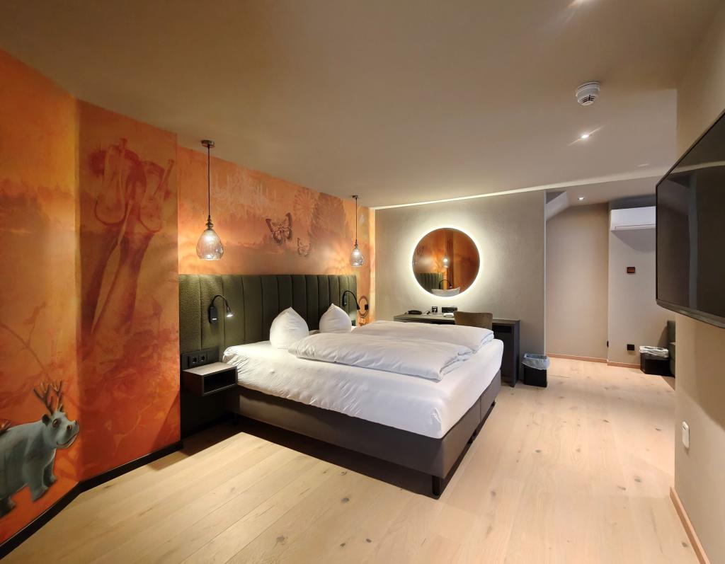 Modernes Hotelzimmer im Sport- und Wellnesshotel Angerhof ****S mit Doppelbett und Wandkunst