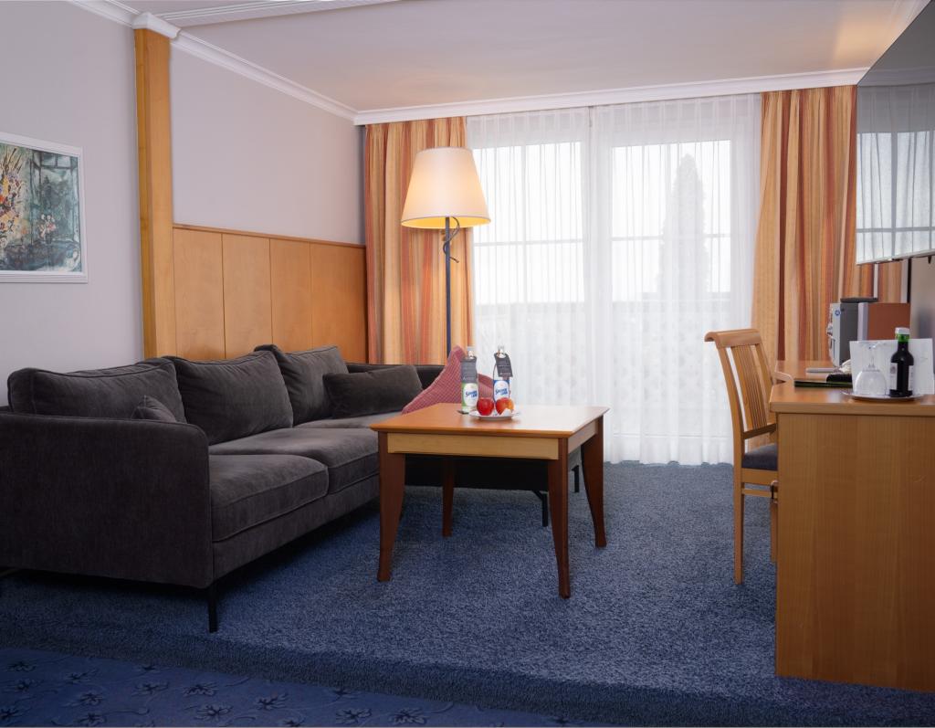 Moderner Wohnbereich im Sport- und Wellnesshotel Angerhof ****S mit Sofa und TV