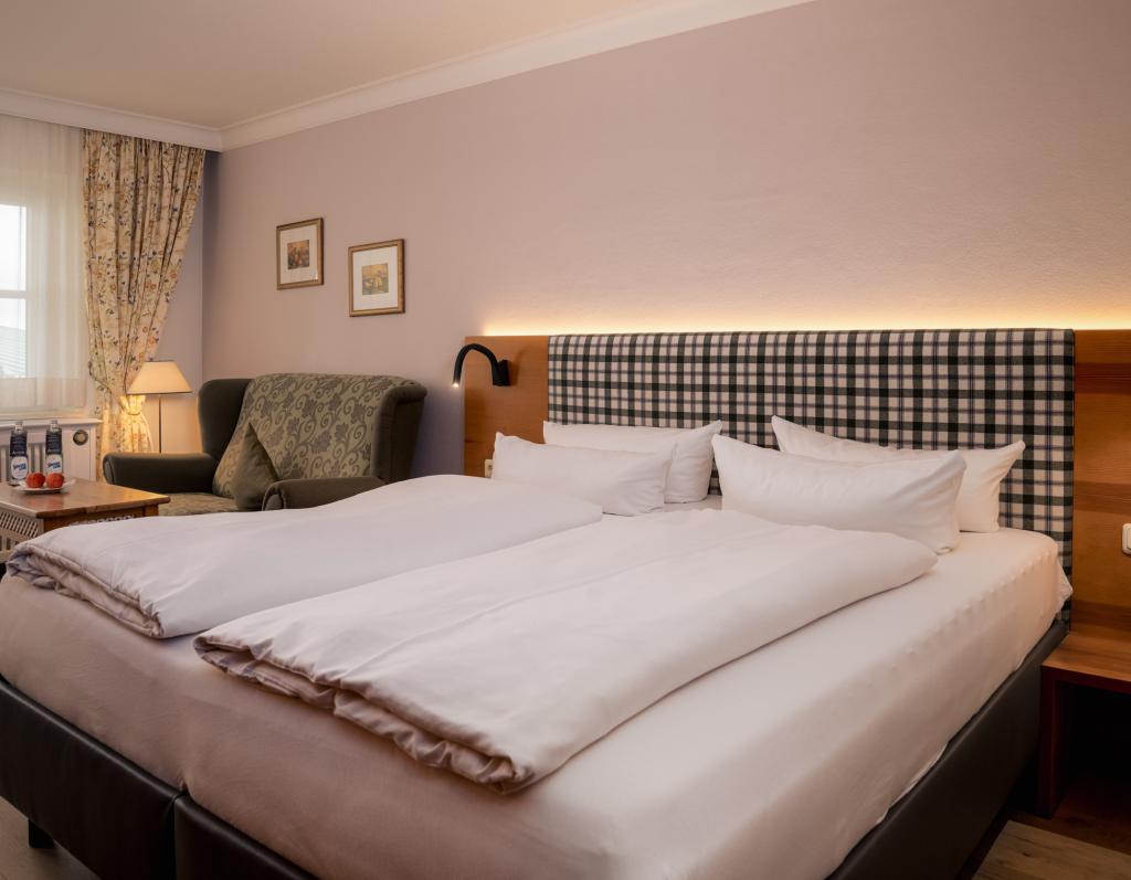 Gemütliches Gästezimmer im Sport- und Wellnesshotel Angerhof ****S mit Doppelbett und Sessel