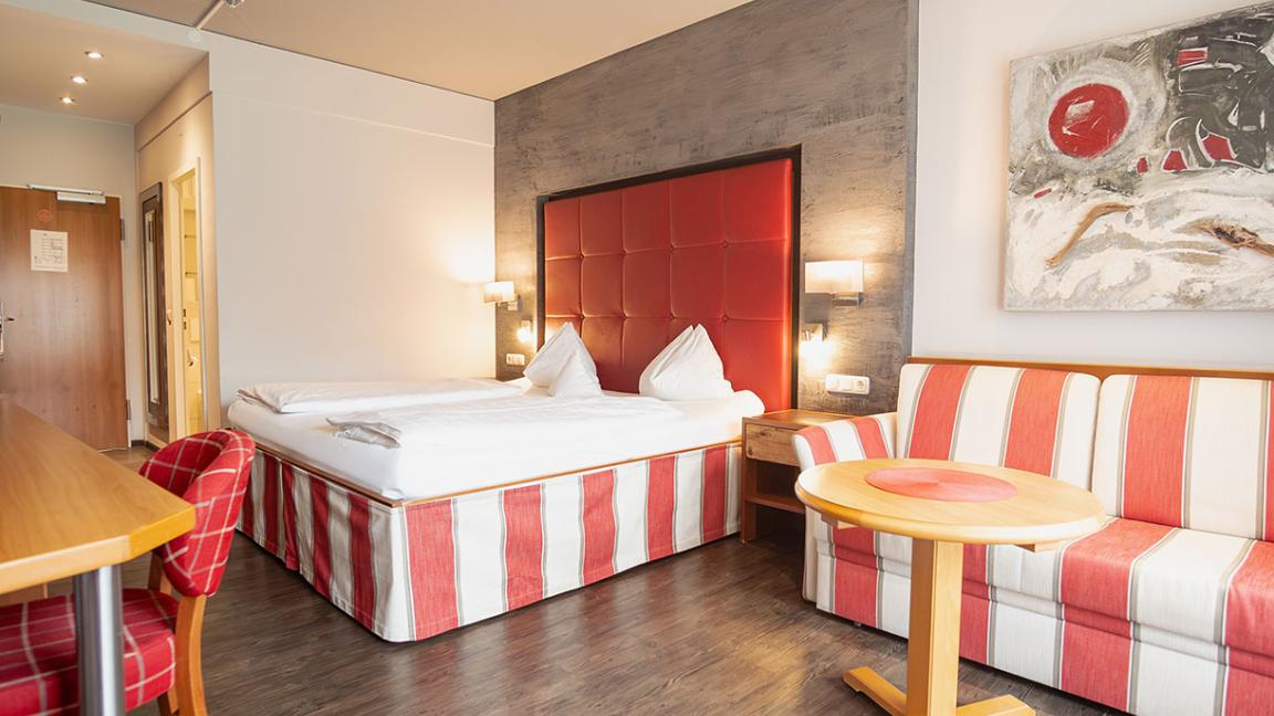 Hotel Sommer Zimmer mit Doppelbett, Schreibtisch und Balkon mit Bergblick