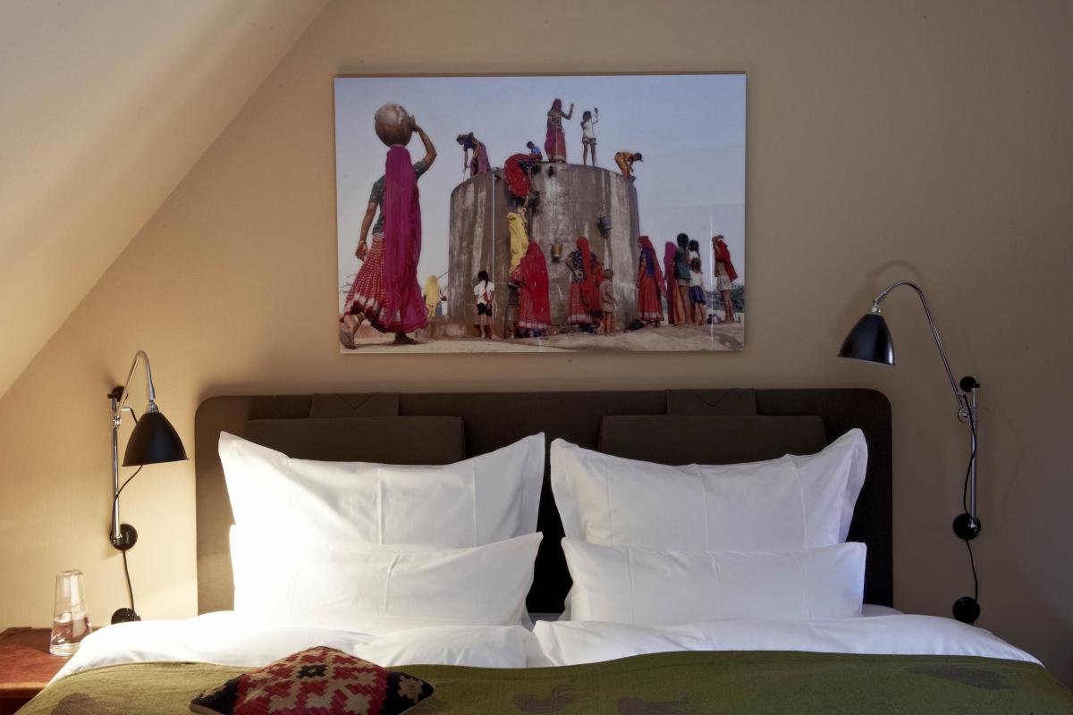 Lösch-Bild über einem Bett zeigt Frauen beim Wasserholen an einem Brunnen