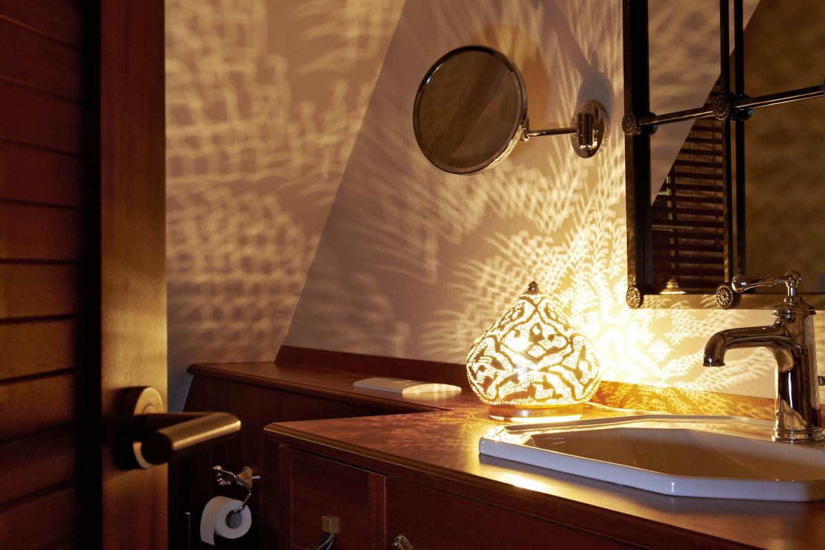 Beleuchtetes Badezimmer mit Holz-Lösch-Details und dekorativen Spiegeln