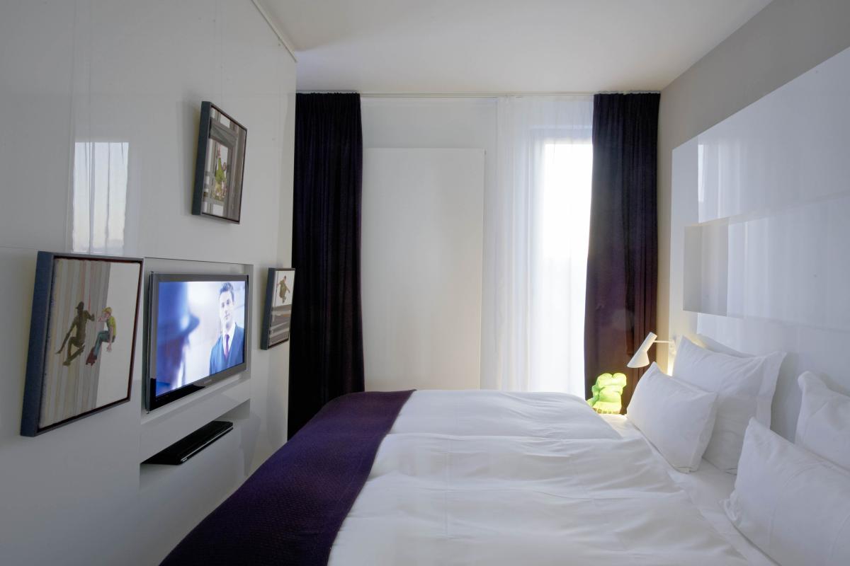 Modernes Gästezimmer mit Lösch Bettdecke und Fernseher an der Wand