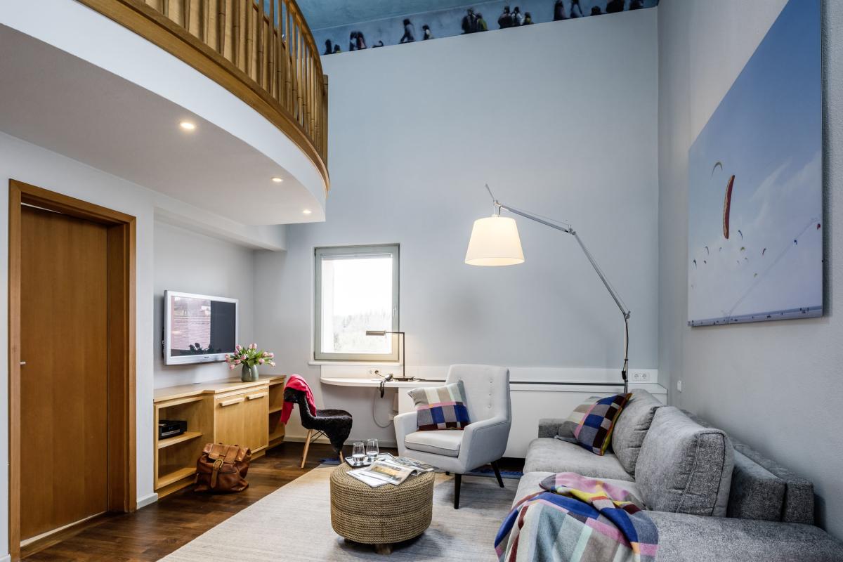 Modernes Wohnzimmer im Kloster Hornbach mit Sitzmöbeln und Holzbalkon