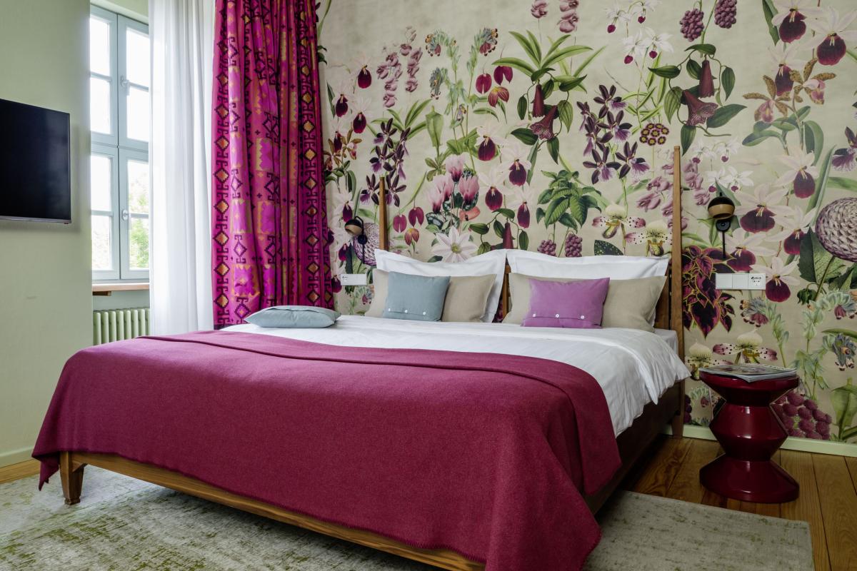 Modernes Schlafzimmer im Kloster Hornbach mit buntem Wandmuster und gemütlicher Einrichtung