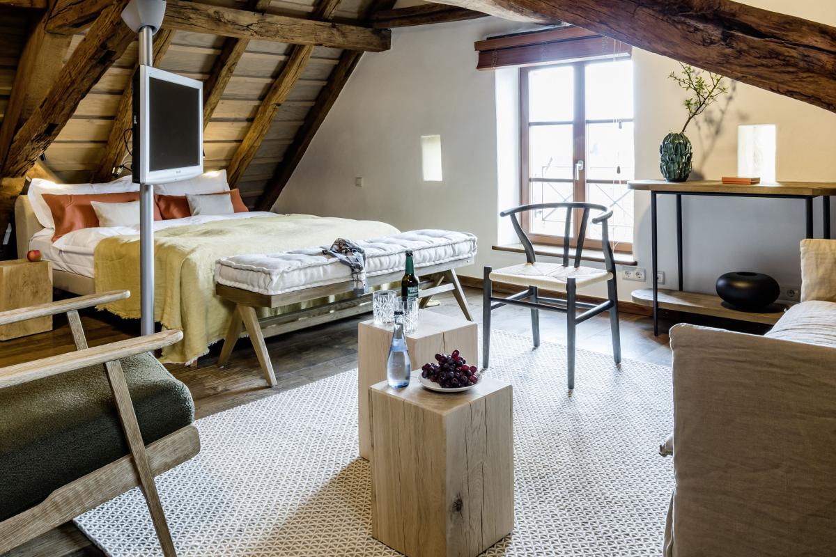 Gemütliches Zimmer im Kloster Hornbach mit sichtbaren Holzbalken und moderner Einrichtung