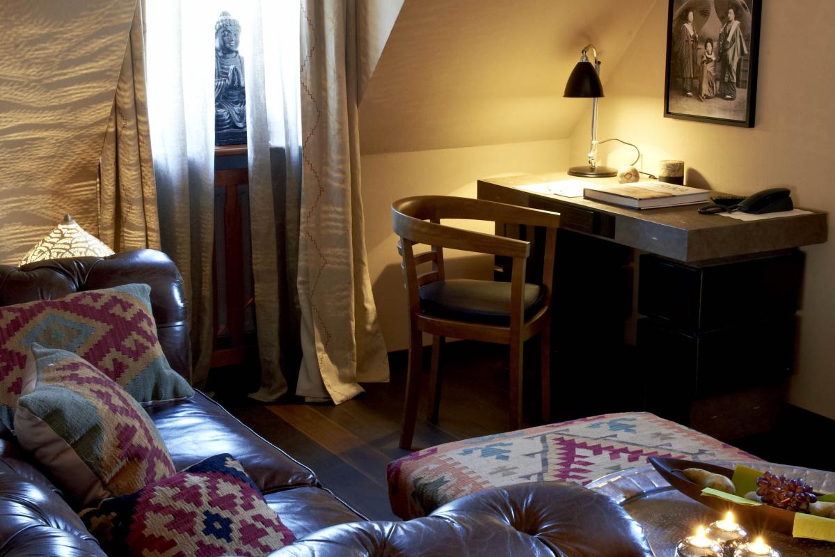 Gemütliches Wohnzimmer mit Löschkerzen auf Tisch und Ledersofa