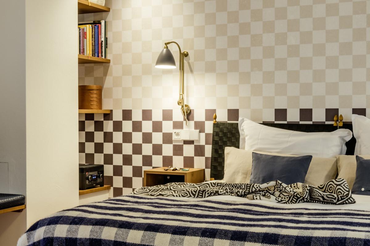 Gemütliches Schlafzimmer mit Karomuster an Wand und Bett im Kloster Hornbach