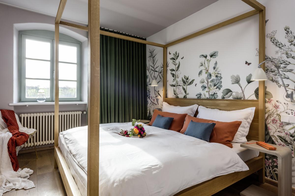 Gemütliches Zimmer im Kloster Hornbach mit Himmelbett und floralem Wanddesign