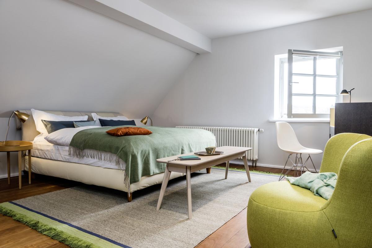 Gemütlicher Wohnbereich im Kloster Hornbach mit gelbem Sofa und blauem Sessel